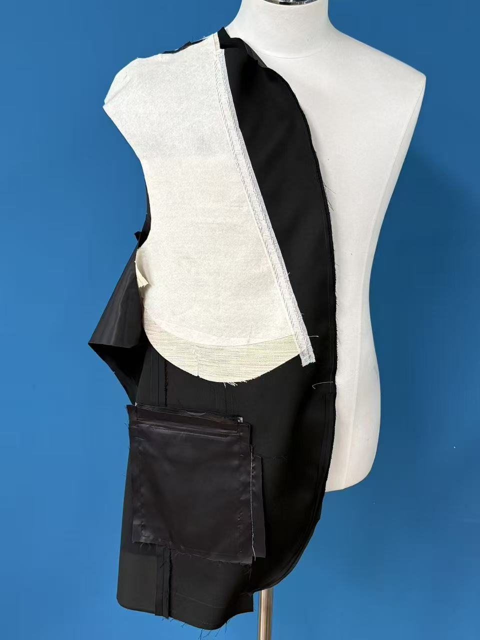 A fused jacket front opened on a stand, white fusible interlining bonded across the entire front panel