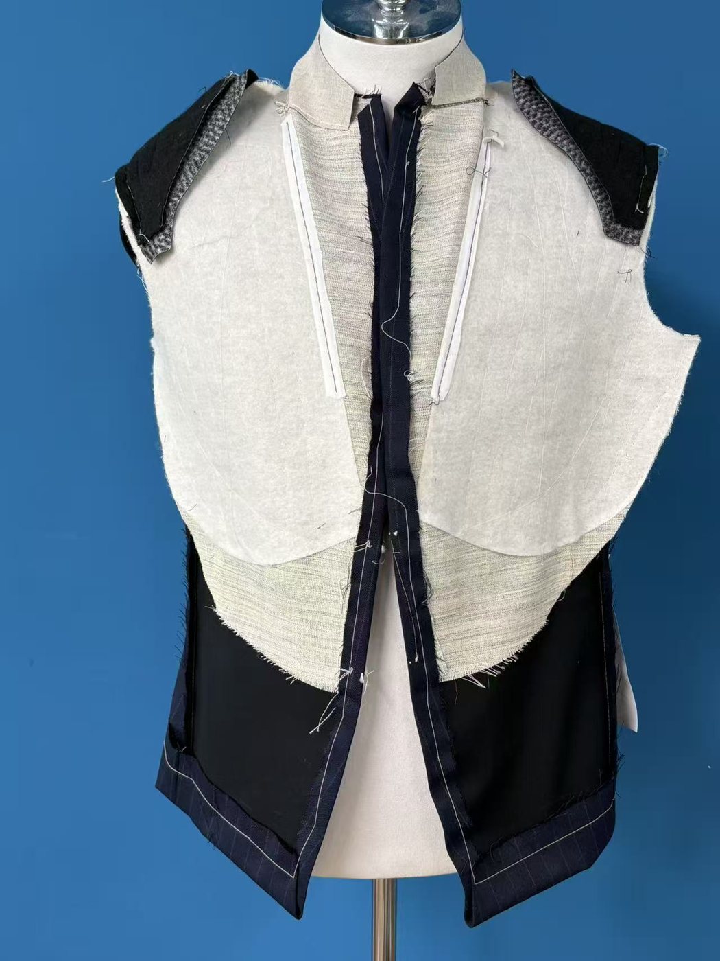 A half canvas jacket front opened on a stand, the canvas piece stopping in a curve above the waist